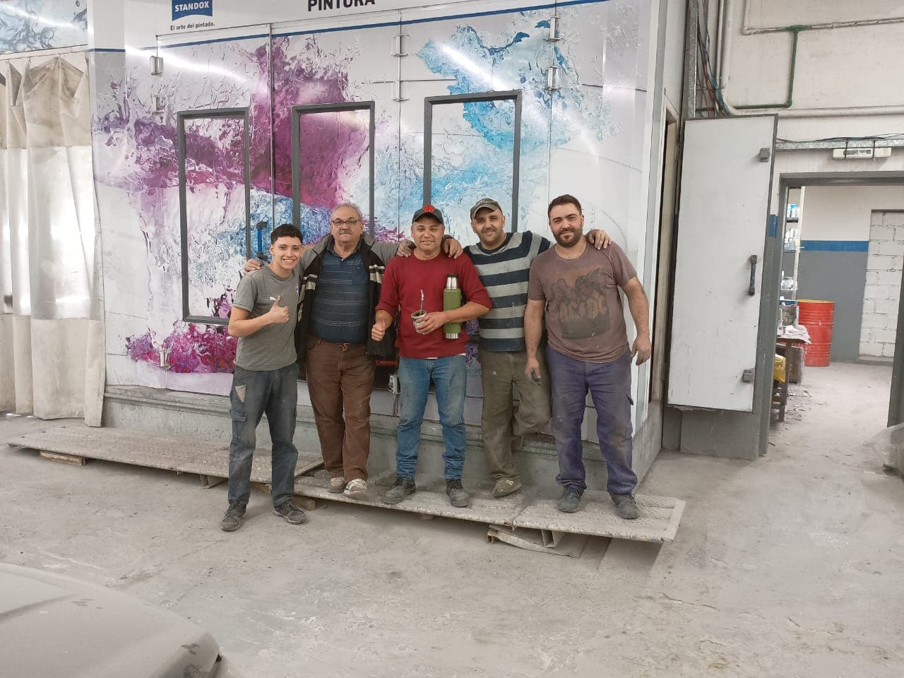 Equipo de INFRAPLUX frente a una cabina de pintura